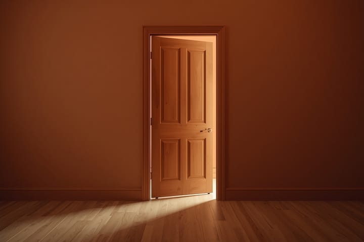 A wooden door left ajar, light spilling through
